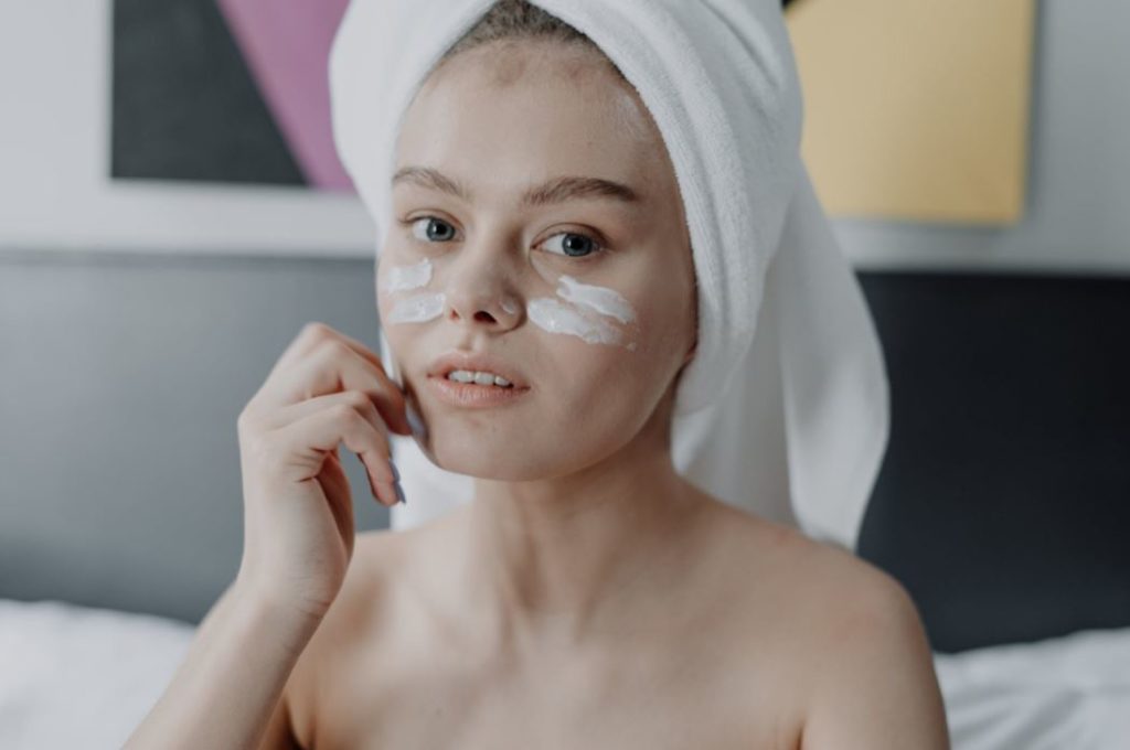 woman applying cream to face